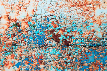 Bright textured weathered grunge background for your design. Rusty metal surface cracked with peeling old blue, green and red paint.