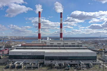 Pipes with white smoke. Pipes of a city gas boiler room with white smoke against a sky. Top view from a drone.	