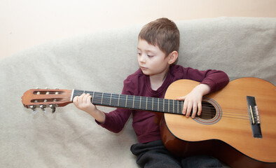 child learns to play the guitar