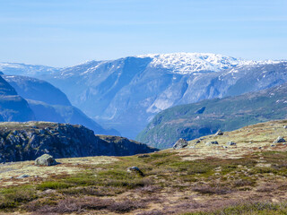 A view on higher parts of Eidfjorden, Norway. Taller mountains have some snow on them. Lush green...