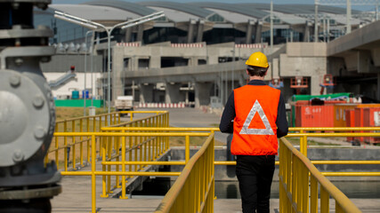 Worker taking note using pen and paper. Women engineer checks equipment at work and records readings.