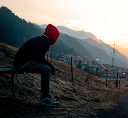 Person sitting down and gazing towards the mountain sunrise