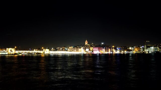 Time lapse footage of ferries in Istanbul at night. Galata Tower and Karakoy district on the background.