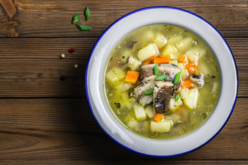 Homemade traditional ukha, fish soup on wooden rustic background. Space for text, top view.