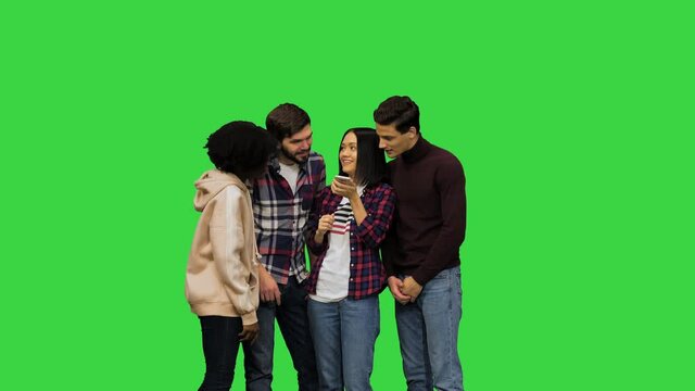 Multicultural group of young students having fun using a voice assistant on their smartphone on a Green Screen, Chroma Key.
