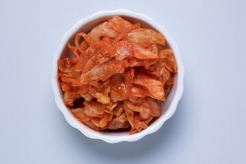 White lettuce kimchi in ceramic cup on white background.