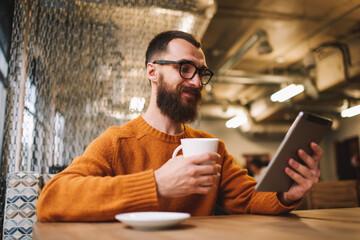 Glad male watching video on tablet during break