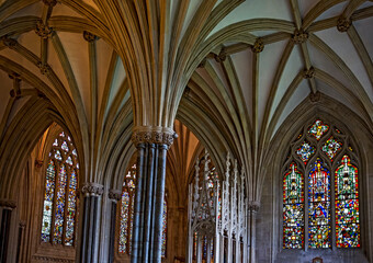 Piers or columns with arched vaulting ribs, ceiling detail with stained glass windows in the interior of the Wells cathedral in Wells, Somerset, England_08222016_019201913.