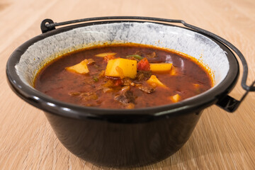 Hungarian Beef Goulash or Gulyas Soup or Stew Served in a Small Cauldron with Potatoes, Meat, Paprika and Pepper