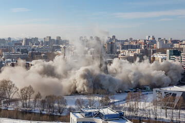A lot of city dust from the fall of a large building in the city center on a sunny day | YEKATERINBURG, RUSSIA - 24 MARCH 2018.