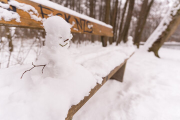 Schneemann auf einer Parkbank
