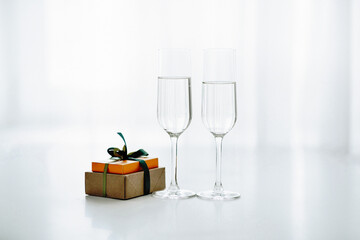 Two glasses of champagne in the background of the window, a gift and a holiday for two
