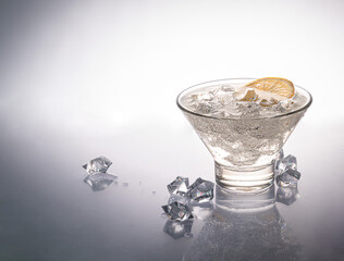 Glasses are filled with ice and cold green tea. Decorated with lemon wedges. On a light background.