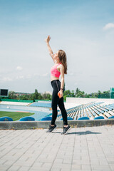 Fototapeta na wymiar Fitness for Female Beginners, woman fitness, physical activity for teenagers. Young sporty girl having workout, running, doing exercises on the stadium