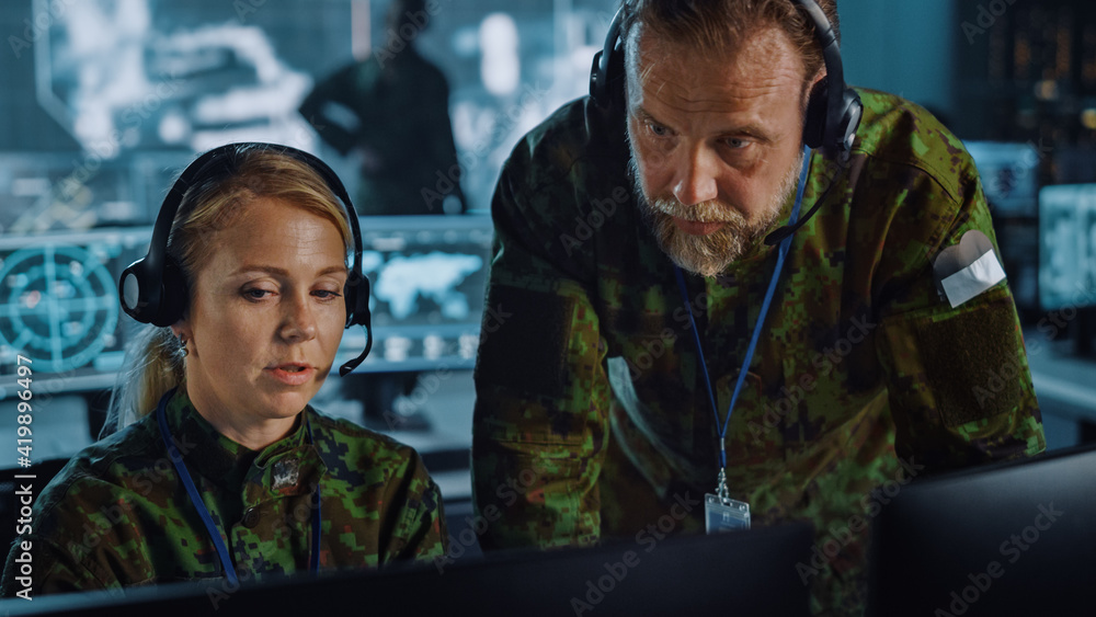 Leinwandbilder military surveillance officers talking next to a computer screen in central office for cyber operati