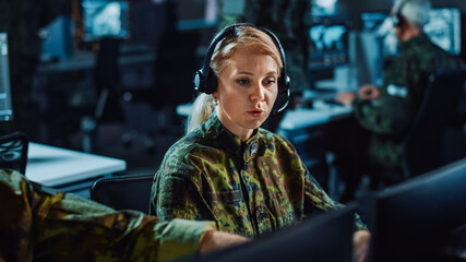 Beautiful Female Military Surveillance Officer in Headset Working in Central Office Hub for Cyber...