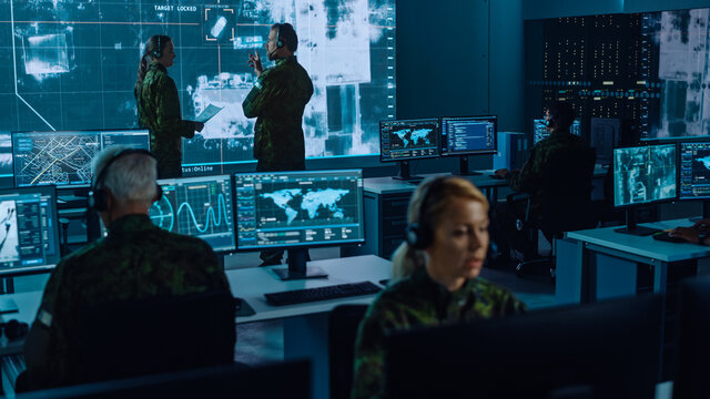 Military Surveillance Team of Officers Locked a Target on a Vehicle from a Satellite and Monitor it on a Big Display in Office for Cyber Operations for Managing Security and Army Communications. 