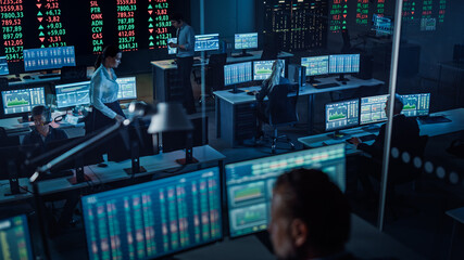 Professional Financial Data Analysts Working in a Modern Monitoring Office with Live Analytics Feed...