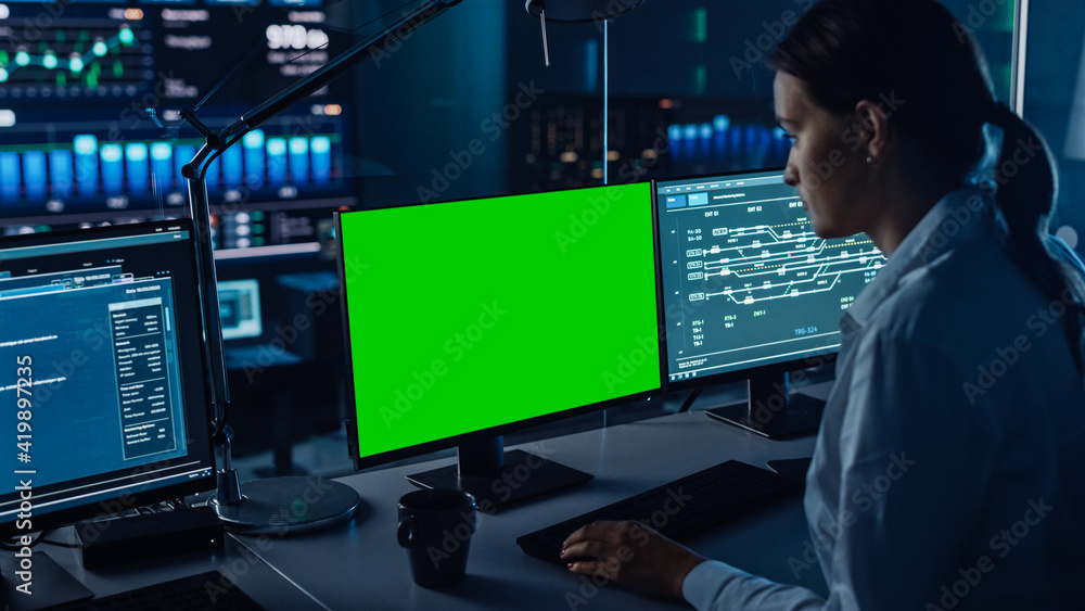 Poster Female Software Engineer Working in a Modern Monitoring Office with Green Screen Mock Up on a Computer Display. Monitoring Room Big Data Scientists and Managers Sit in Front of Computers.