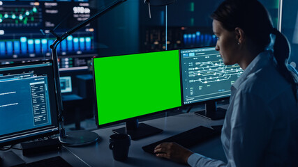 Female Software Engineer Working in a Modern Monitoring Office with Green Screen Mock Up on a...