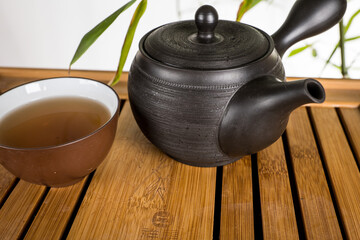 preparation of green loose tea in traditional Japanese ceramics - obrazy, fototapety, plakaty