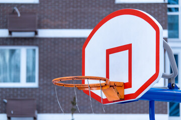 The torn basketball basket in the yard.