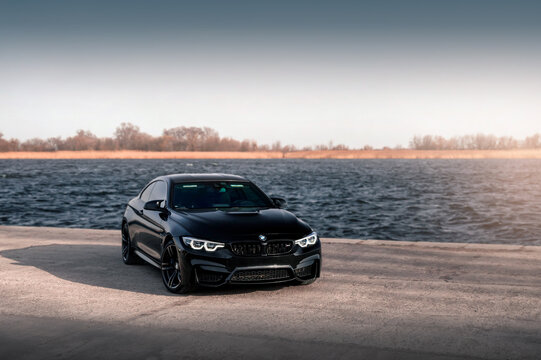 Kherson, Ukraine - March 2019. BMW M4 F82 Competition in a black color on a background of the river.