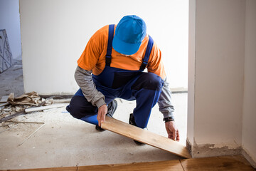 Handyman installing ceramic tiles in brand new building