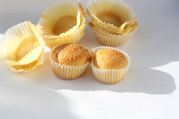 Used baking packaging and two vanilla muffins on a white plate.