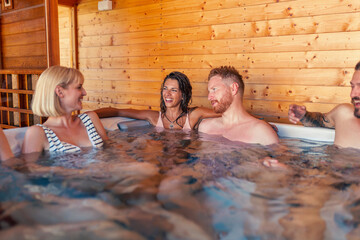 Friends relaxing and having fun in a hot tub while on a vacation