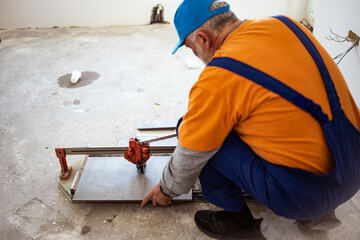 Handyman cutting ceremic tiles on the flor