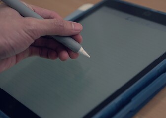 hand with pen​ stylus on tablet