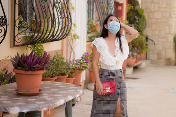 Asian woman touring in Andalusia Spain during covid19 - young happy and beautiful Japanese girl in face mask enjoying holidays travel walking traditional street in Seville town