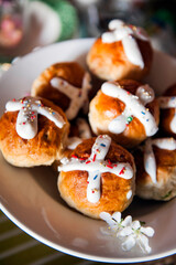 Homemade Easter traditional hot cross buns and painted eggs on a gray background