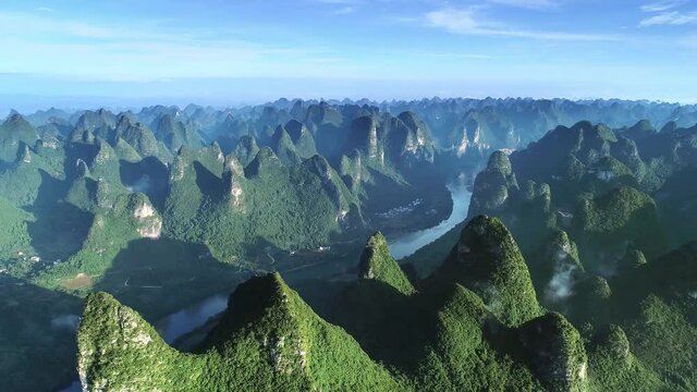 Aerial view of a karst landscape, Li River passing through mountains with towns along it in Guilin, Guangxi