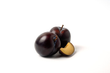 Fototapeta premium Whole and sliced black cherry plums on white background