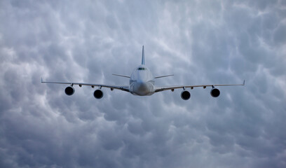Passenger airplane flying over snowy mountains - White passenger airplane rising over amazing clouds