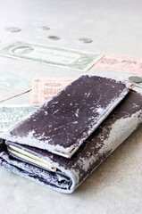 A very old wallet on the table and money. Vertical position. Selective focus.