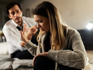 Husband and wife are arguing at home. Angry man is yelling at his wife.