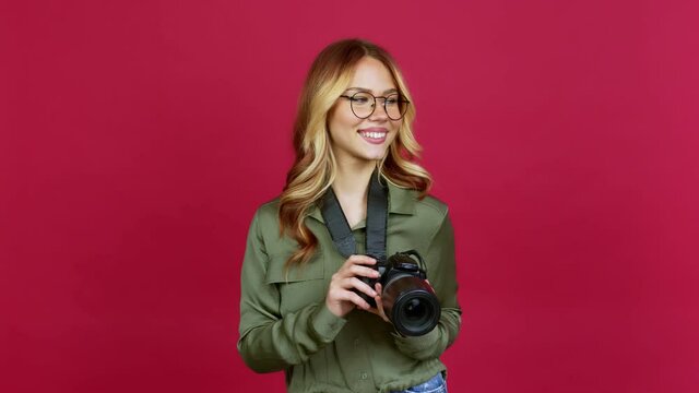 Young blonde girl photographer standing and looking to the side over isolated background