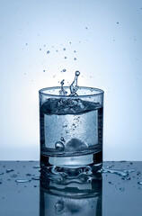 Splash of water in a glass. Splashing water. Ice water. Concept. High quality photo