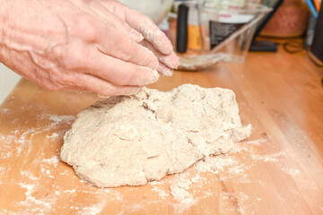 Person making bread in home kitchen adding ingredients to make the dough