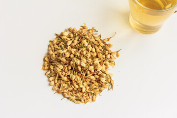 Jasmine green tea, dried jasmine and a cup of green jasmine tea on white background.  Top view, copy space, stock photo