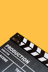 Fototapeta na wymiar Film clapperboard on yellow studio background