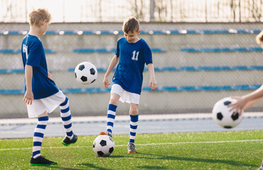 Two Boys Juggling Balls on Training Drill. Child Kicking Ball. Group of School Football Players on Practice Session