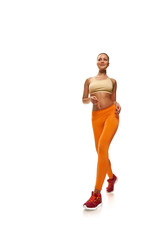 Portrait of young healthy strong sportswoman jogging on white background