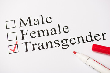 Above photo of red color marker and paper with text male female and transgender isolated on the white background