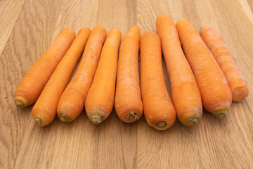 Some fresh carrots on wooden background - the benefits of carrots