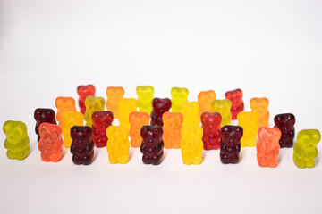 army ranks of colorful bright gummy bears isolated on white background
