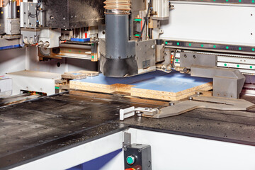 The process of manufacturing cabinet furniture from chipboard on a modern automatic woodworking machine.